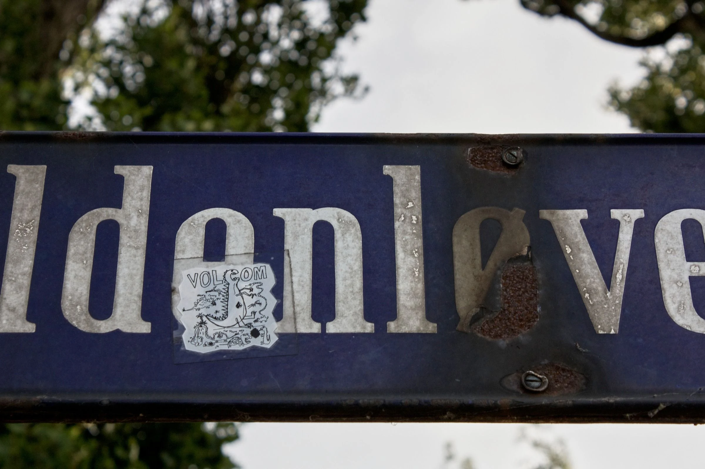 Painted lettering on a weathered blue sign