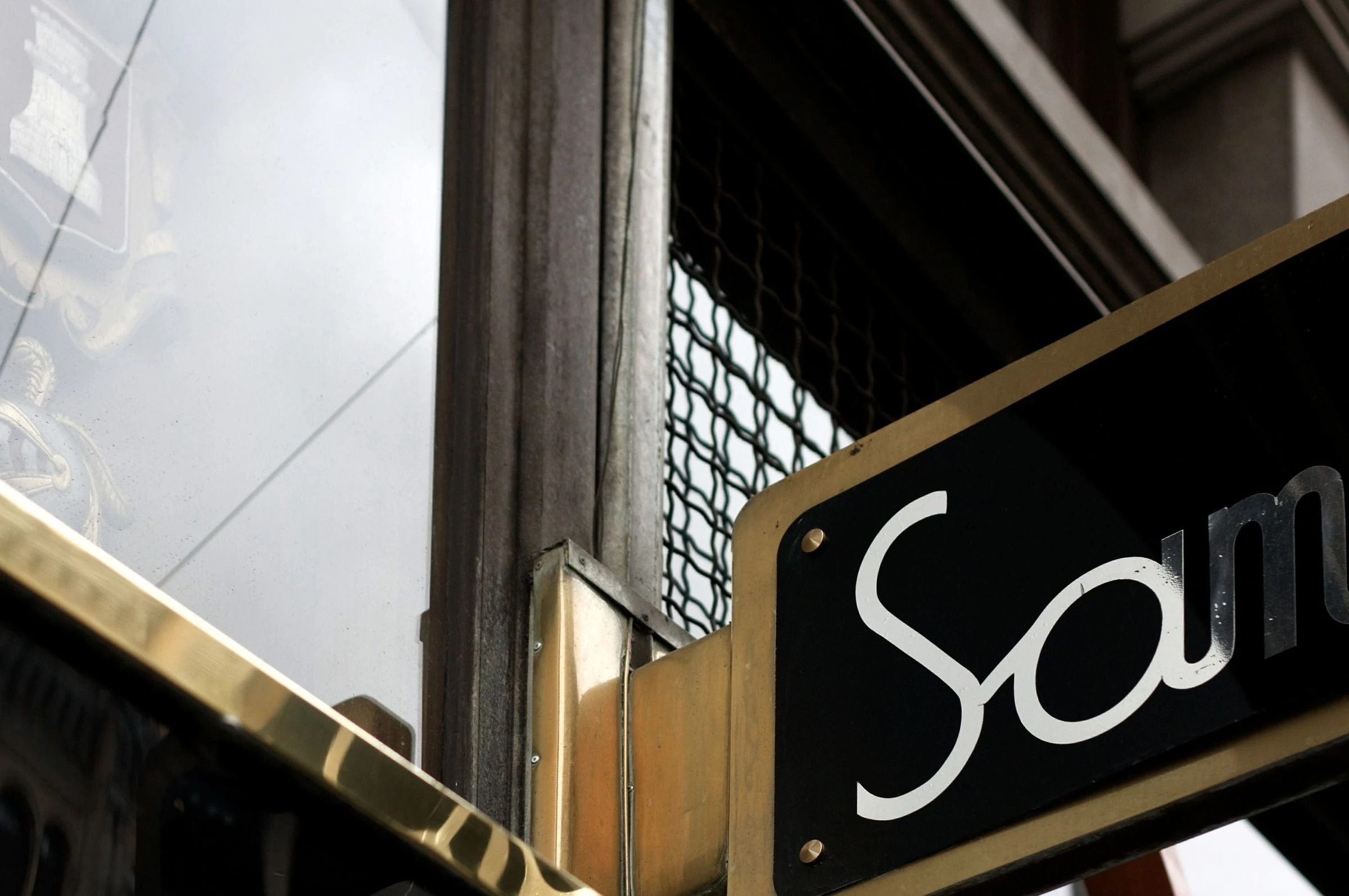 White script on a projecting black sign