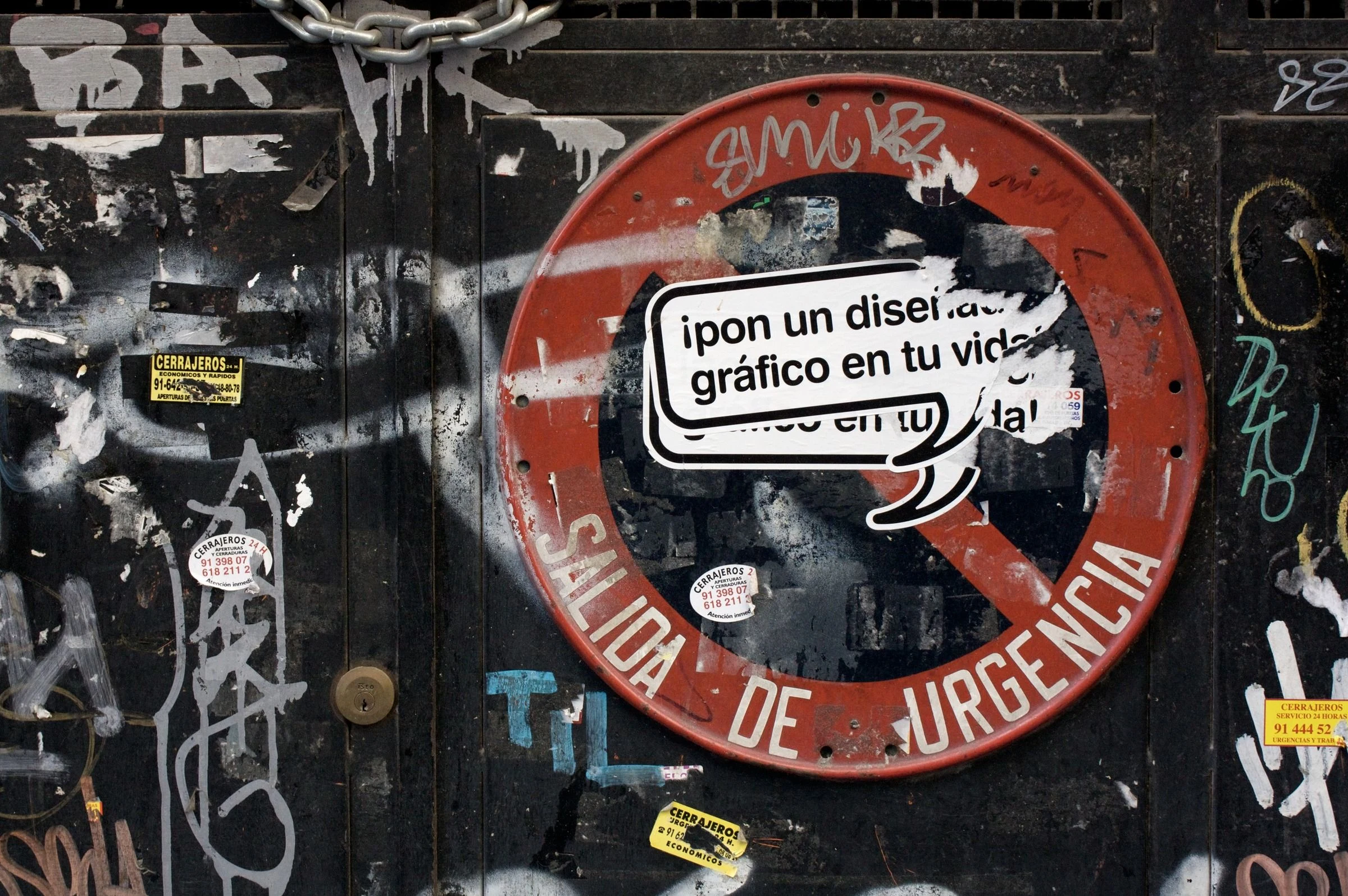 Stickers and lettering layered over a street sign