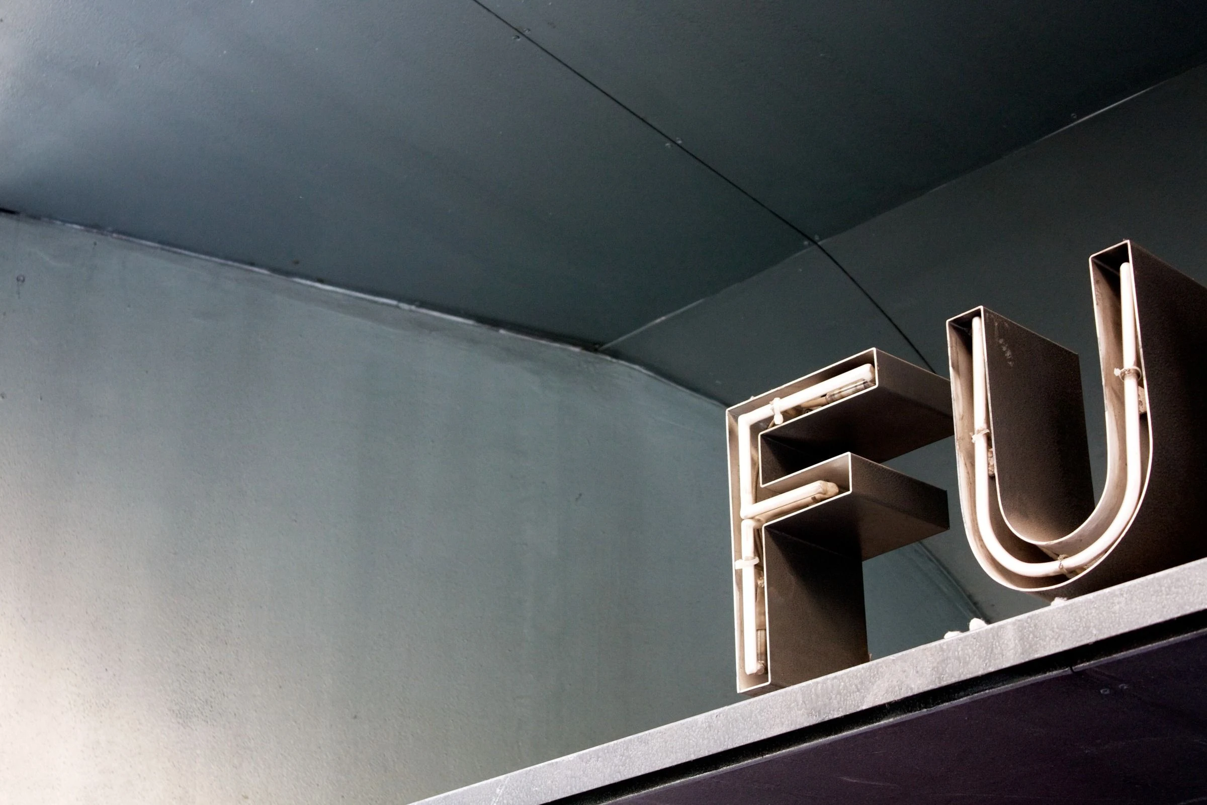 Metal letters against a blue-gray facade