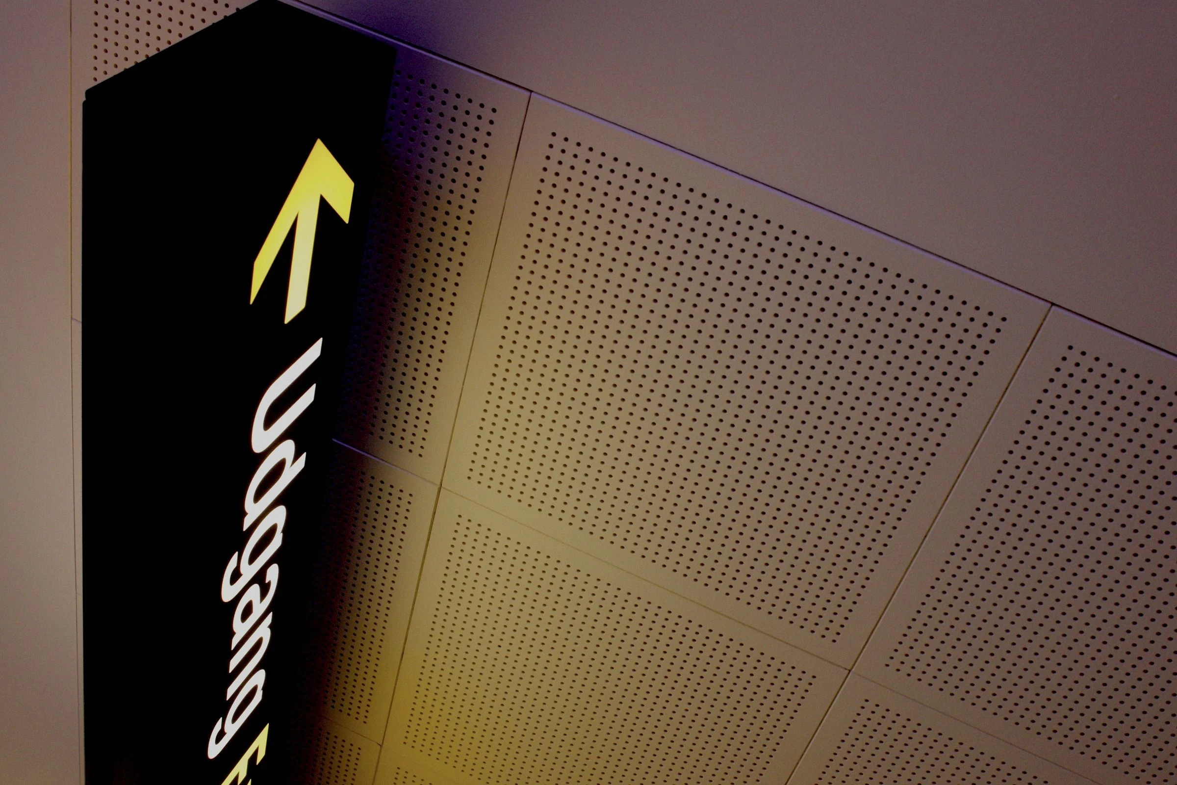 Vertical illuminated lettering on a dark sign