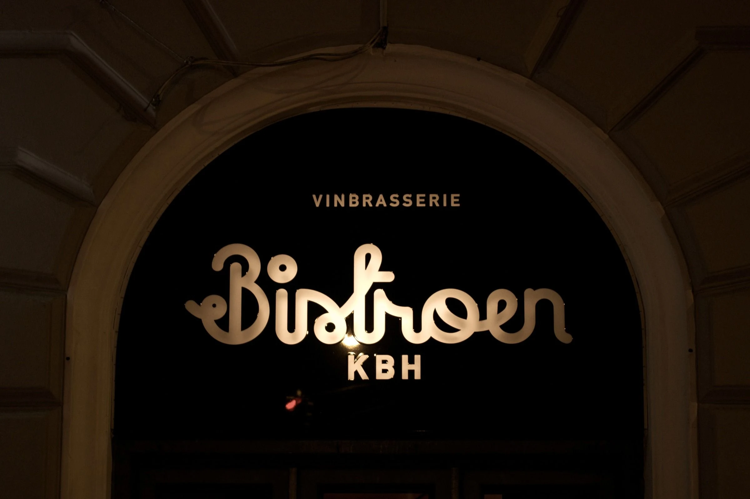 Script lettering above an arched doorway