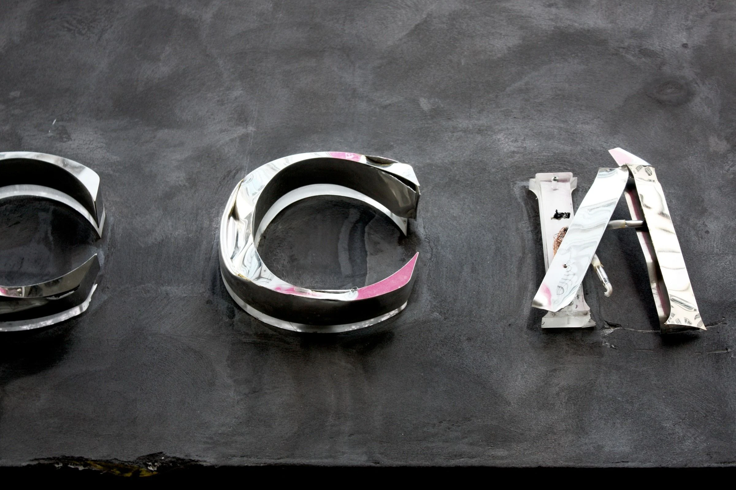 Metal letters mounted on a dark wall