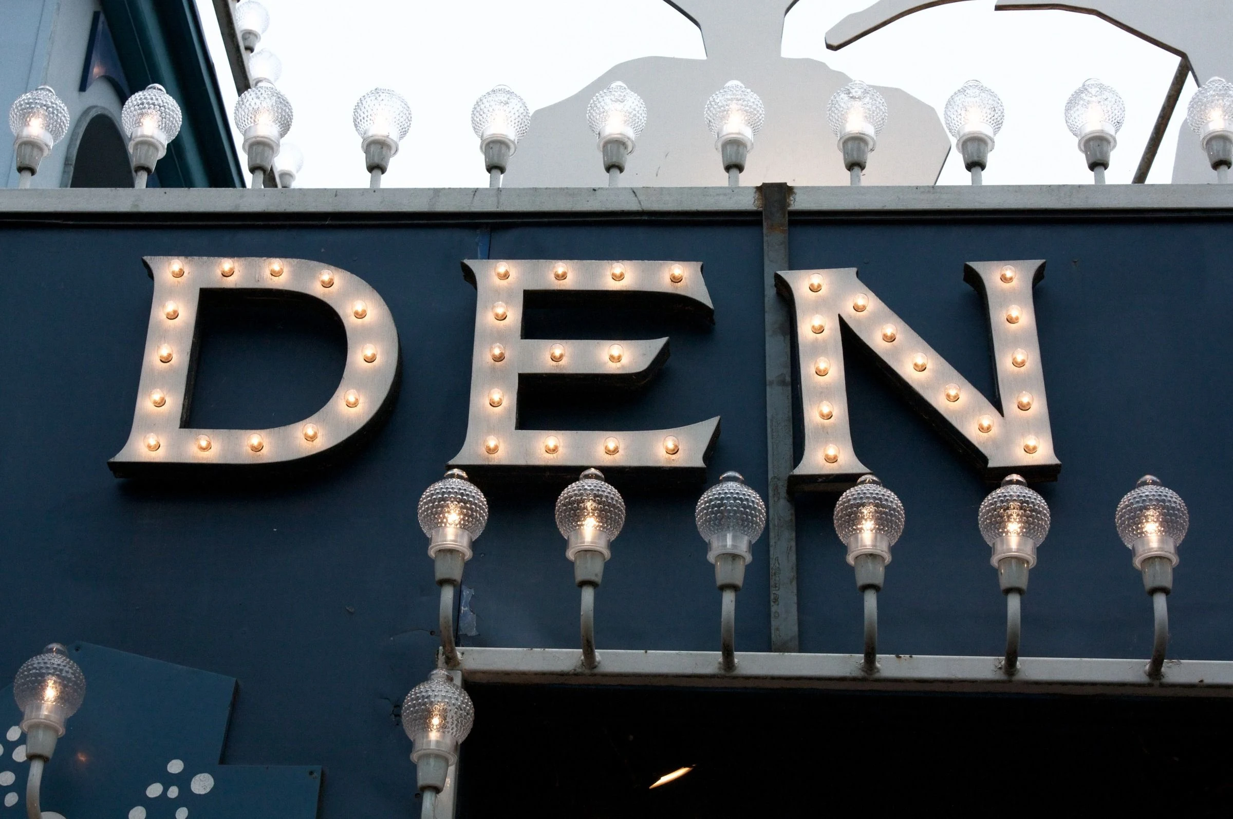 Raised letters and decorative lamps on a facade